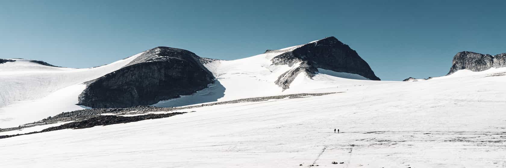 Two people crossing the Styggebreen glacier towards Galdhøpiggen.