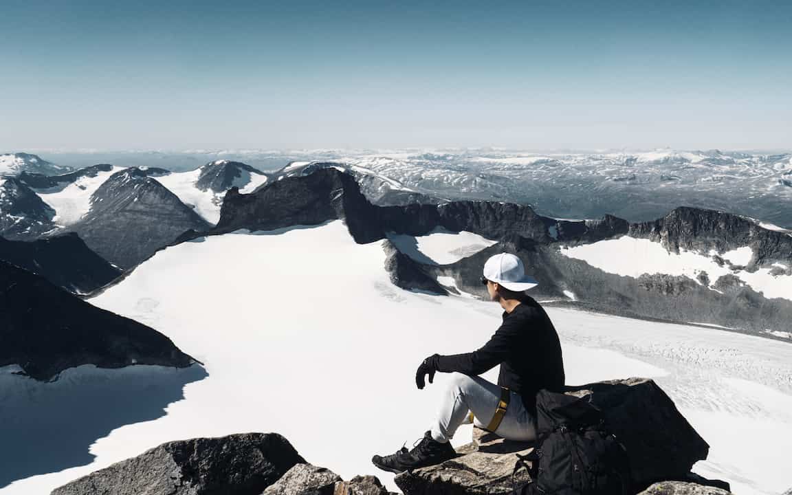 Harald sitting on Galdhøpiggen mountain top, with a view over Jotunheimen.