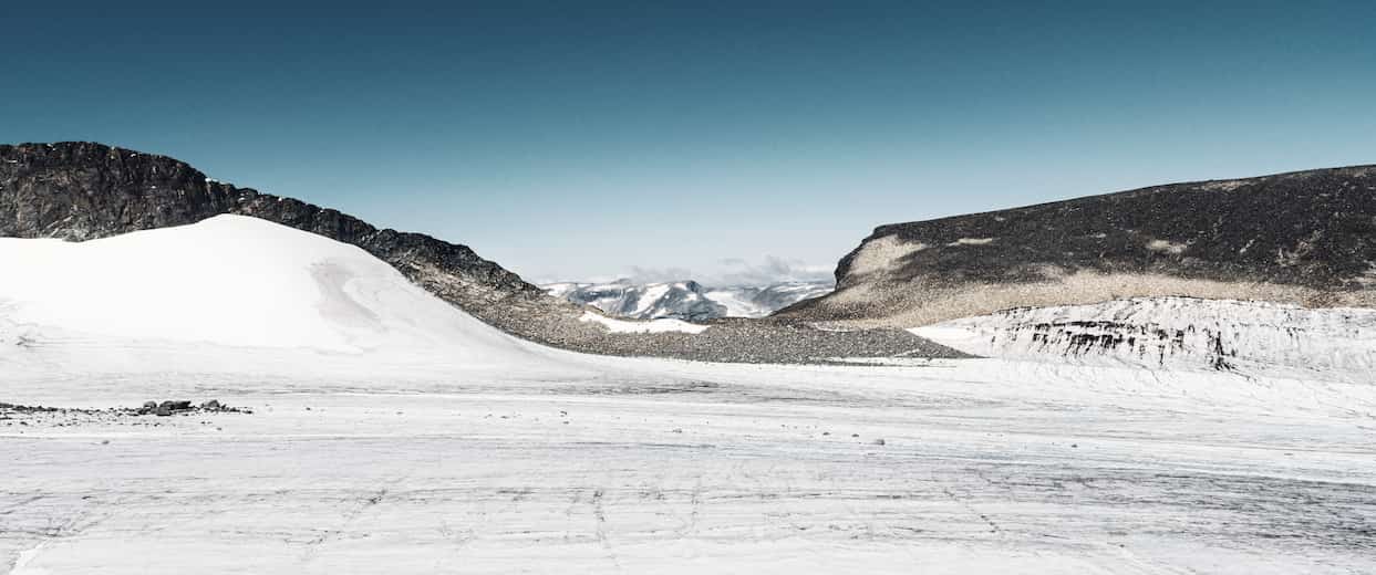 View over Styggebreen glacier with two mountain hills on the side.